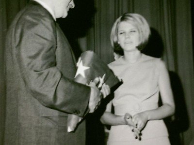 Sandy Moppert and principal handing over flag